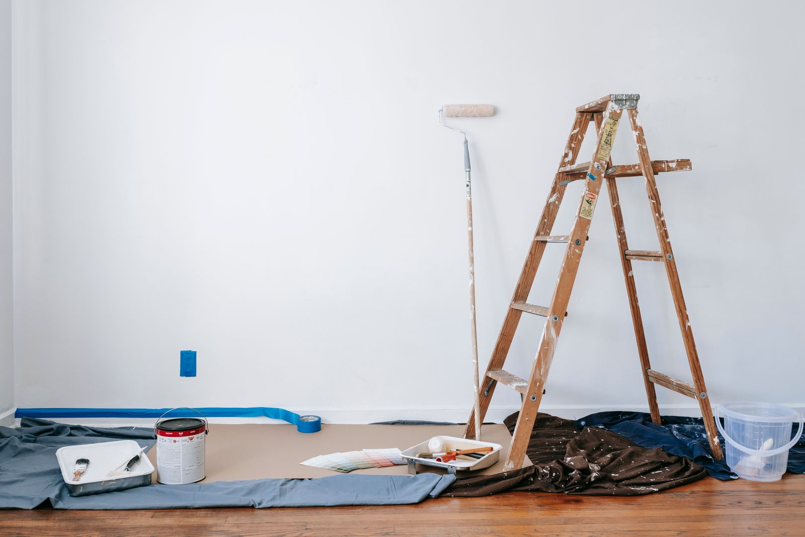Ladder, roller, and paint prepared for a room