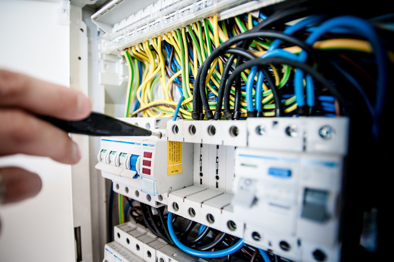 Electrician working inside a wired breaker panel